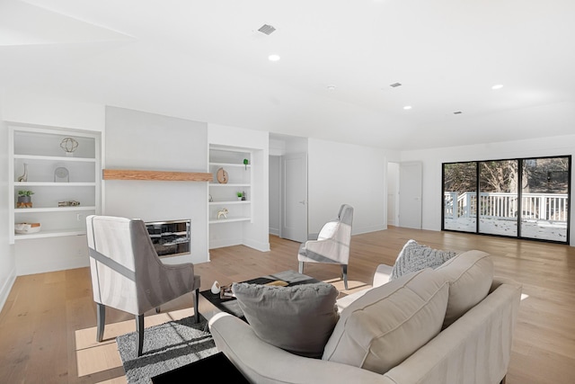 living room with built in features, baseboards, light wood-type flooring, and recessed lighting