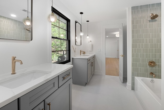 bathroom featuring washtub / shower combination, two vanities, tile patterned floors, and baseboards
