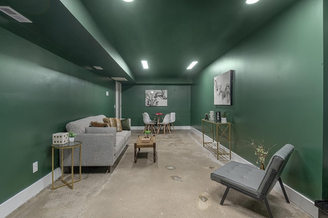 living area with baseboards and concrete flooring