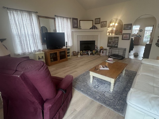 1040 Charlie Daniels Pkwy Unit 105, Mount Juliet, TN 37122 - living area with wood finished floors, a tiled fireplace, arched walkways, and lofted ceiling
