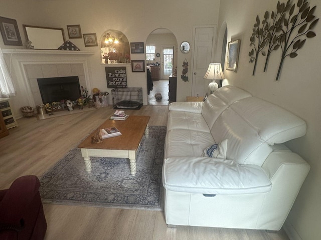 1040 Charlie Daniels Pkwy Unit 105, Mount Juliet, TN 37122 - living room featuring wood finished floors, arched walkways, and a tiled fireplace