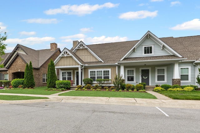 2044 Mainstream Dr, Franklin, TN 37064 - view of front facade with board and batten siding, a chimney, a shingled roof, a front lawn, and covered porch