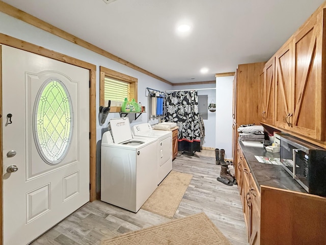 washroom with washer and dryer, cabinet space, and light wood-type flooring