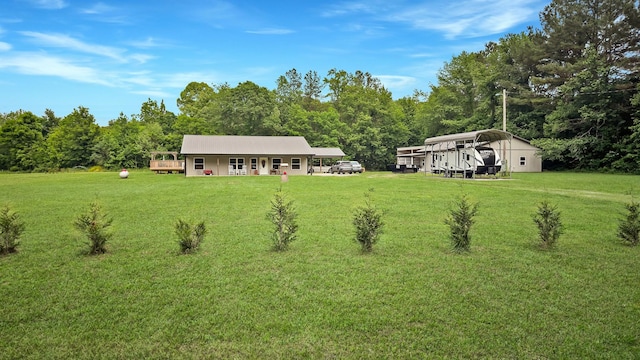 back of property featuring a detached carport, a yard, and a deck