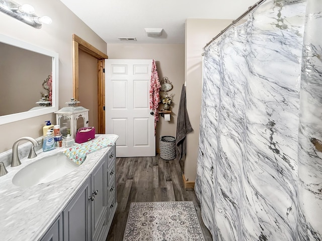 bathroom with wood finished floors, vanity, and curtained shower