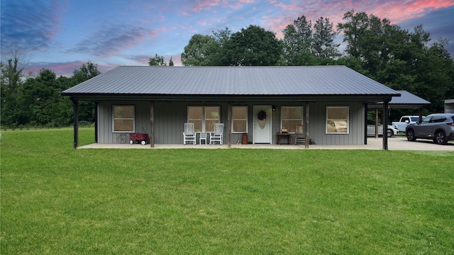 view of front facade featuring a porch, a lawn, board and batten siding, and metal roof