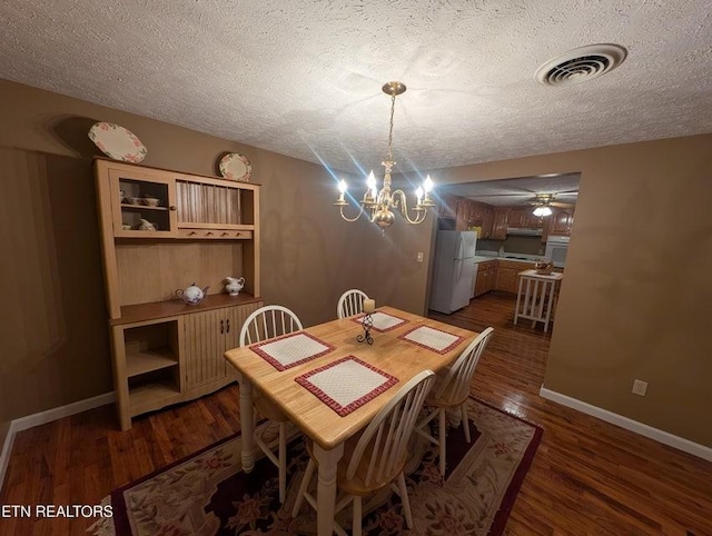 1729 Roslin Rd, Jamestown, TN 38556 - dining area featuring a textured ceiling, a chandelier, dark wood-type flooring, and a ceiling fan