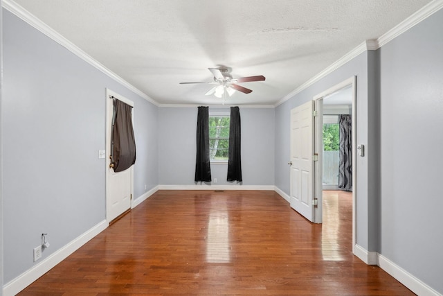 unfurnished room featuring wood finished floors, a ceiling fan, ornamental molding, baseboards, and a textured ceiling