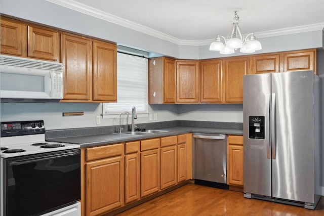 kitchen with stainless steel appliances, a sink, a chandelier, dark countertops, and light wood finished floors