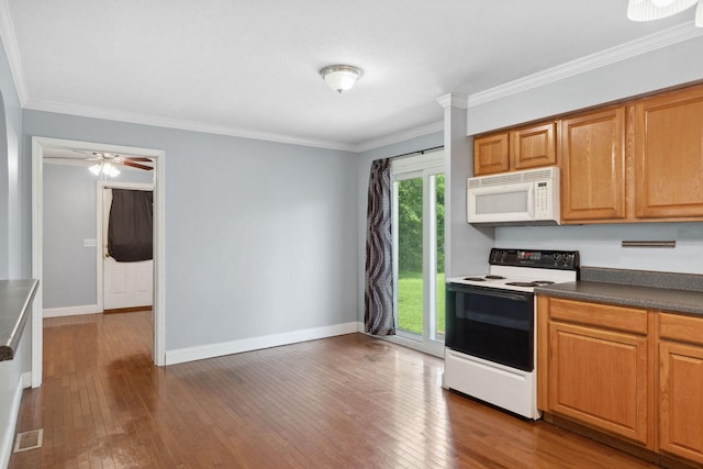 kitchen featuring electric range oven, white microwave, wood-type flooring, baseboards, and crown molding
