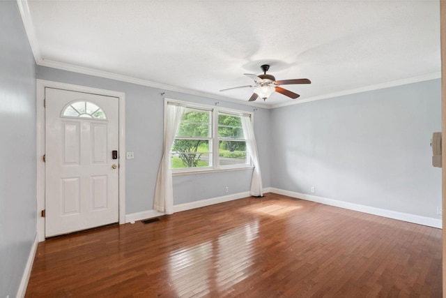 foyer with healthy amount of natural light, ceiling fan, wood-type flooring, baseboards, and crown molding