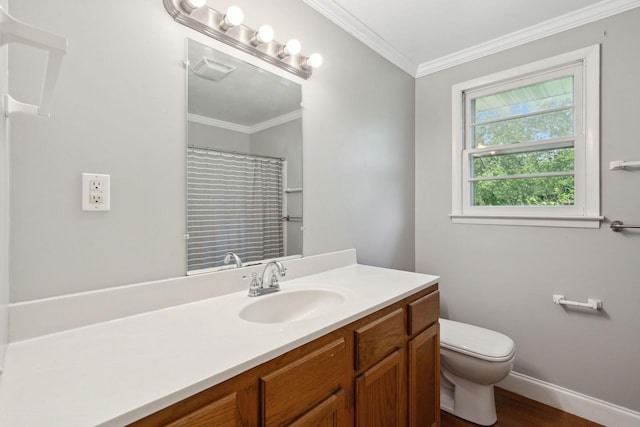 bathroom featuring toilet, vanity, baseboards, crown molding, and wood finished floors