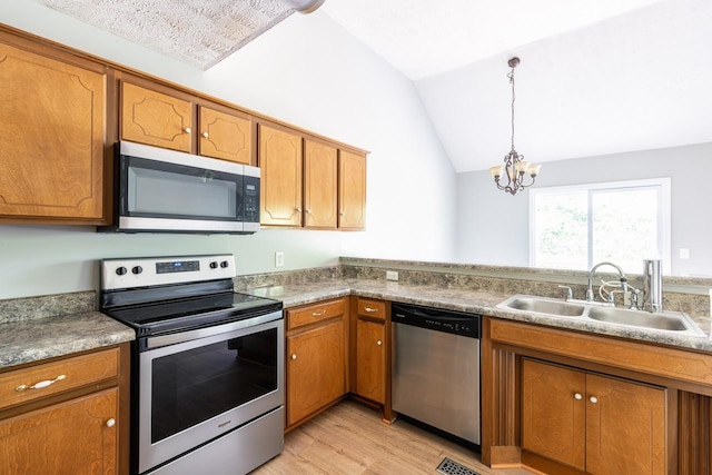 309 Yacht Ct, Smyrna, TN 37167 - kitchen with stainless steel appliances, a sink, brown cabinetry, light wood-style floors, and lofted ceiling