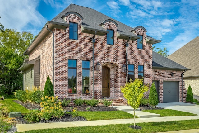 french country style house with brick siding, driveway, and a shingled roof