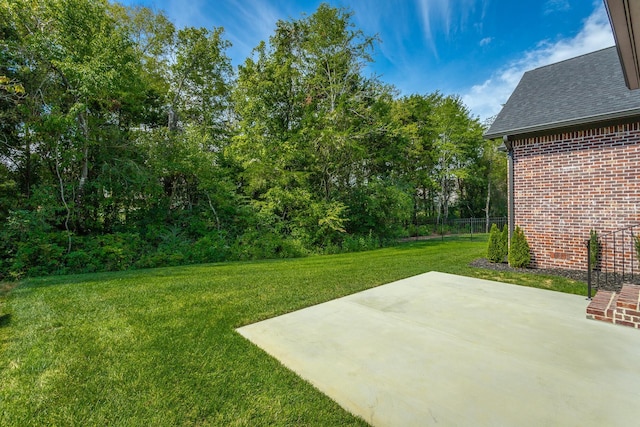 view of green lawn featuring a patio