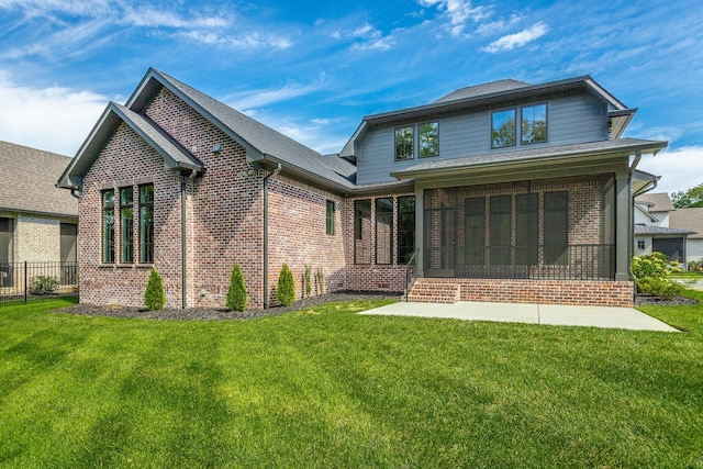 rear view of house with brick siding, a sunroom, and a shingled roof