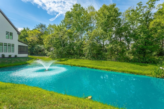 view of swimming pool with a water view and a yard