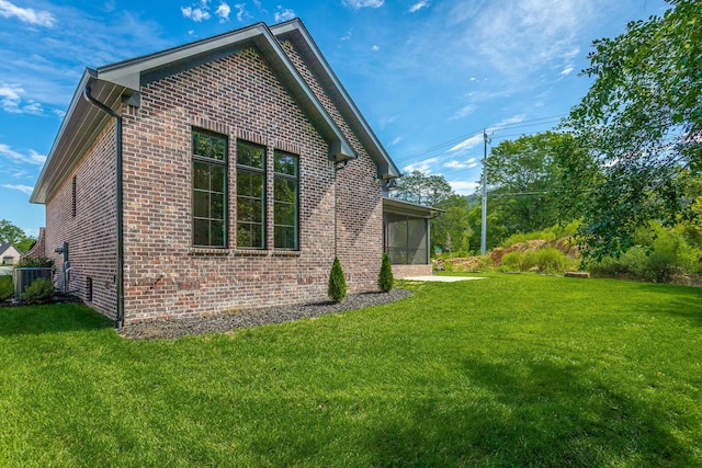 rear view of house featuring brick siding and a lawn
