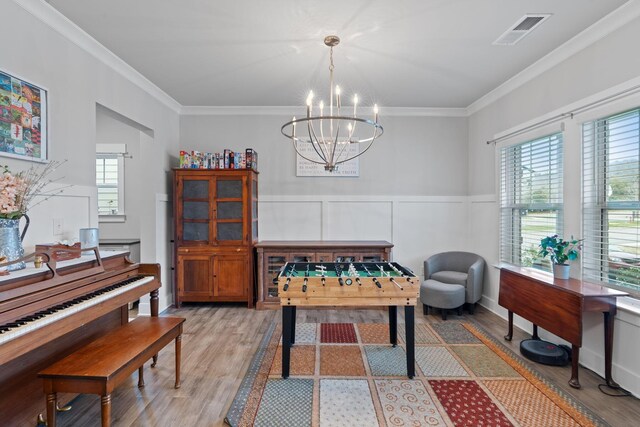 7587 Highborne Ln, Ooltewah, TN 37363 - game room with light wood-type flooring, a chandelier, ornamental molding, and wainscoting