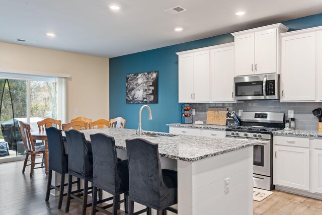 7587 Highborne Ln, Ooltewah, TN 37363 - kitchen with appliances with stainless steel finishes, a sink, a center island with sink, tasteful backsplash, and recessed lighting
