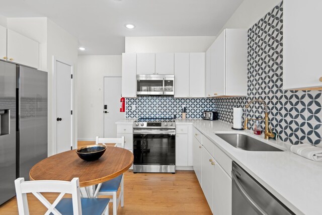 121 Old Mountain Rd, Chattanooga, TN 37409 - kitchen featuring appliances with stainless steel finishes, light wood-type flooring, light countertops, white cabinets, and recessed lighting