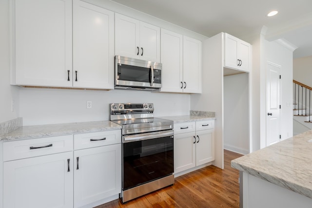 5008 Swan Rd, Chattanooga, TN 37416 - kitchen featuring appliances with stainless steel finishes, light wood-type flooring, white cabinetry, light stone counters, and recessed lighting