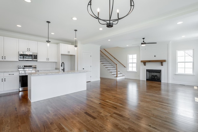 5008 Swan Rd, Chattanooga, TN 37416 - kitchen with appliances with stainless steel finishes, a kitchen island with sink, a fireplace, recessed lighting, and white cabinets
