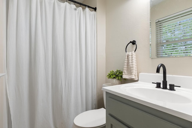 full bath with vanity, toilet, and curtained shower