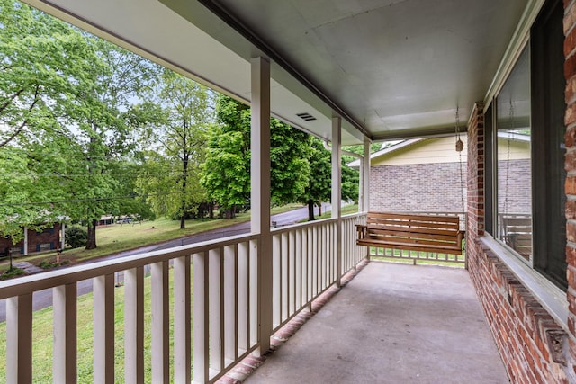 balcony featuring a porch and view of wooded area