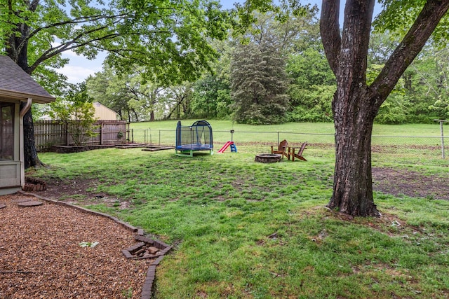 view of yard featuring a fire pit and a trampoline