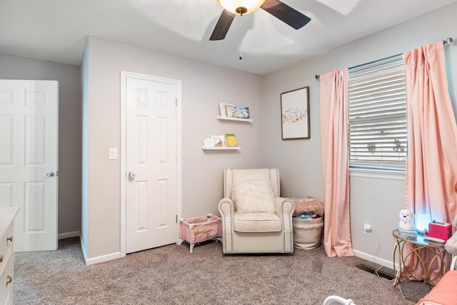 living area featuring carpet floors, ceiling fan, and baseboards