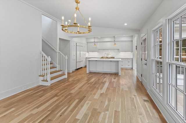 215 Lewisburg Ave, Franklin, TN 37064 - kitchen featuring backsplash, light wood finished floors, light countertops, a chandelier, and lofted ceiling