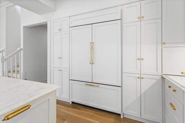 215 Lewisburg Ave, Franklin, TN 37064 - kitchen with built in refrigerator, light wood-style floors, white cabinets, and light stone countertops