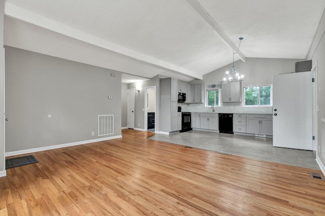 unfurnished living room featuring light wood-style flooring, a chandelier, baseboards, and a sink
