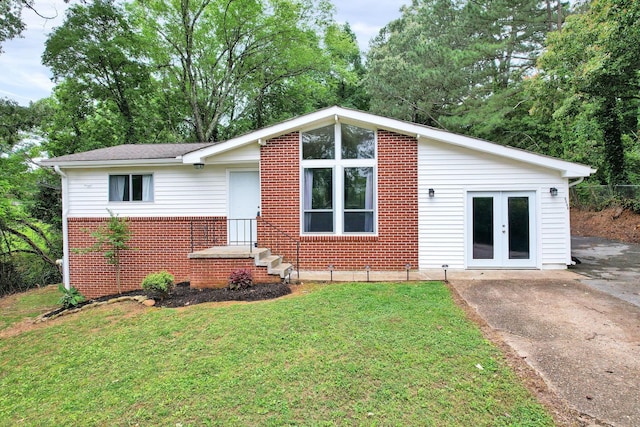 mid-century inspired home featuring brick siding, a front lawn, and french doors