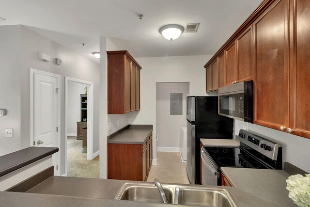 7230 Althorp Way Unit W 12, Nashville, TN 37211 - kitchen with stainless steel appliances, a sink, baseboards, dark countertops, and brown cabinetry