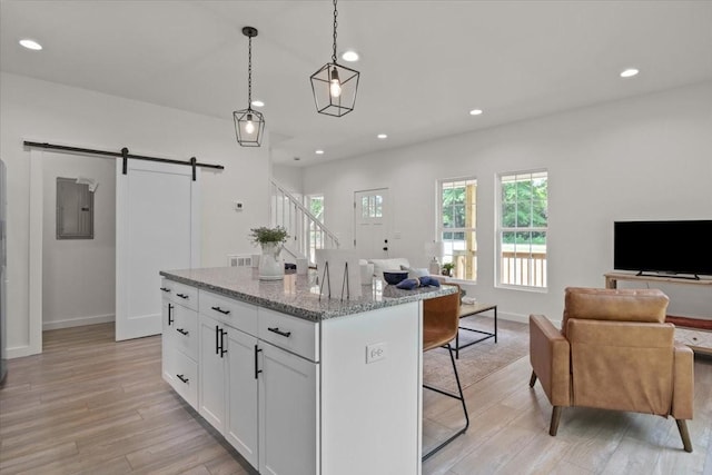 1014 Promise Land Rd, Charlotte, TN 37036 - kitchen with a barn door, open floor plan, a breakfast bar area, light wood finished floors, and recessed lighting
