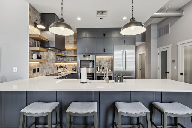 205 31st Ave N Unit 111, Nashville, TN 37203 - kitchen featuring appliances with stainless steel finishes, decorative backsplash, a peninsula, open shelves, and light countertops