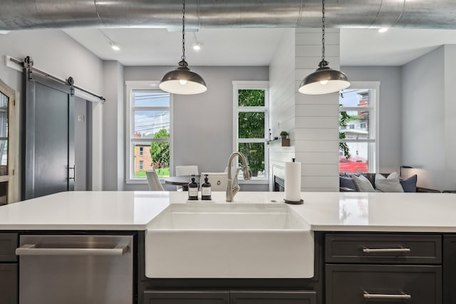 205 31st Ave N Unit 111, Nashville, TN 37203 - kitchen with a sink, stainless steel dishwasher, a barn door, and light countertops