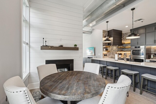 205 31st Ave N Unit 111, Nashville, TN 37203 - dining space featuring light wood-style flooring and a glass covered fireplace