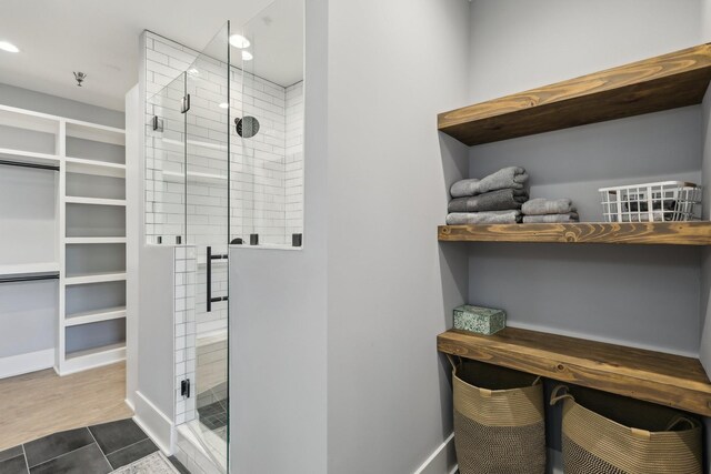 205 31st Ave N Unit 111, Nashville, TN 37203 - bathroom with a stall shower, a spacious closet, baseboards, and recessed lighting