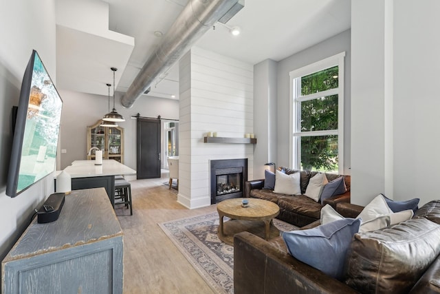 205 31st Ave N Unit 111, Nashville, TN 37203 - living room featuring a barn door, light wood finished floors, and a large fireplace