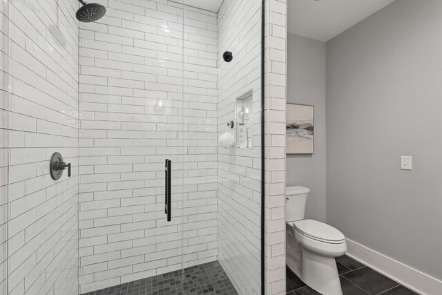 205 31st Ave N Unit 111, Nashville, TN 37203 - bathroom with a shower stall, toilet, tile patterned flooring, and baseboards