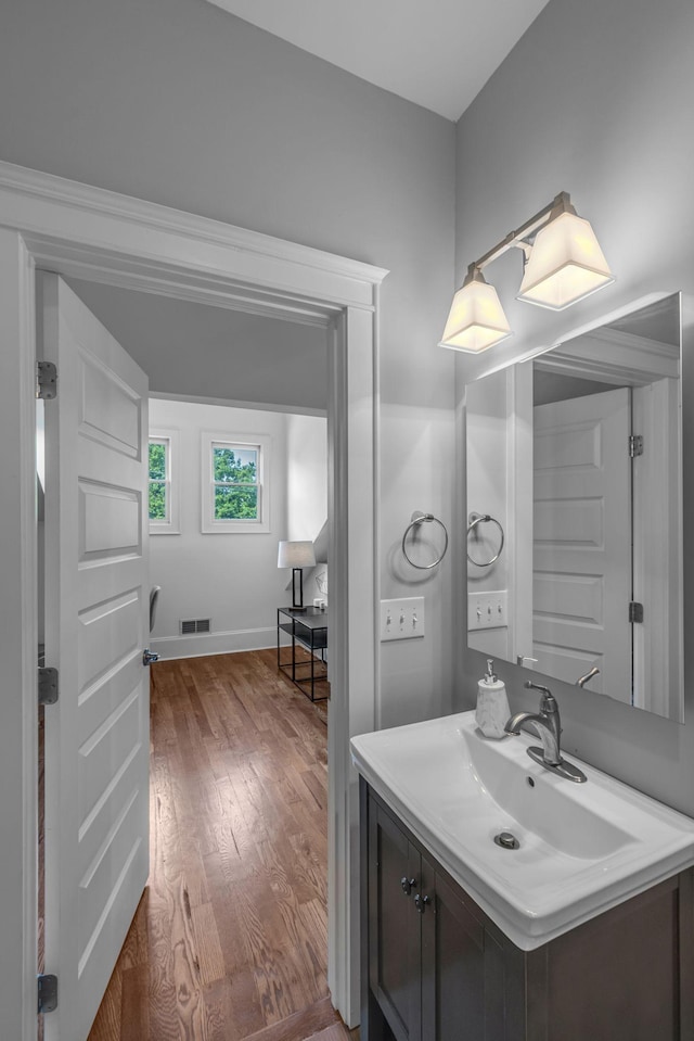 bathroom with wood finished floors, vanity, and baseboards