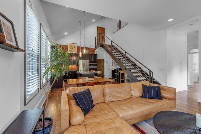 living room with wood finished floors, stairway, a high ceiling, and recessed lighting