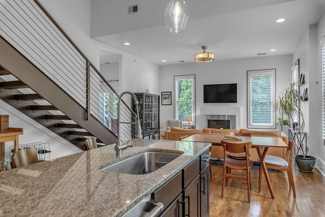 kitchen featuring a sink, a fireplace, hardwood / wood-style flooring, recessed lighting, and pendant lighting