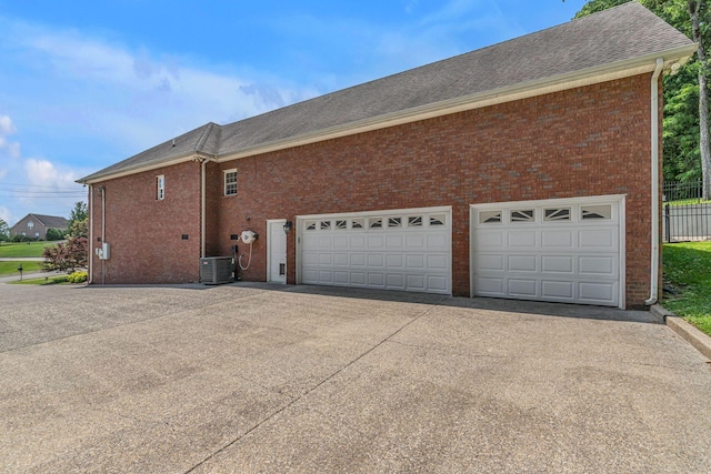 212 Spirit Hill Cir, Smyrna, TN 37167 - view of side of home with central AC, driveway, brick siding, a shingled roof, and fence