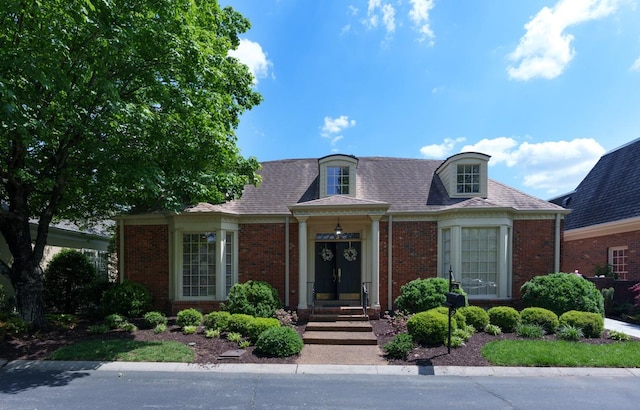 new england style home featuring brick siding
