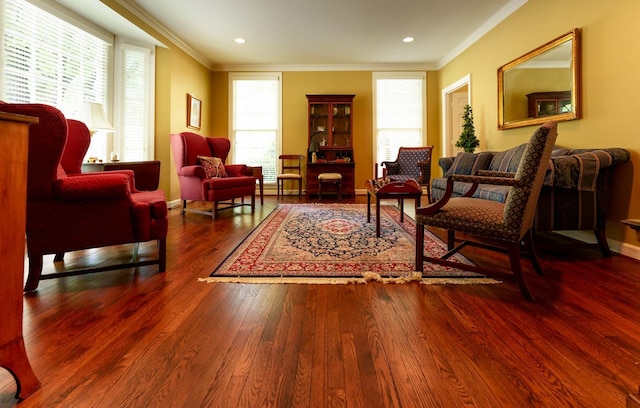 sitting room with wood finished floors, crown molding, baseboards, and recessed lighting