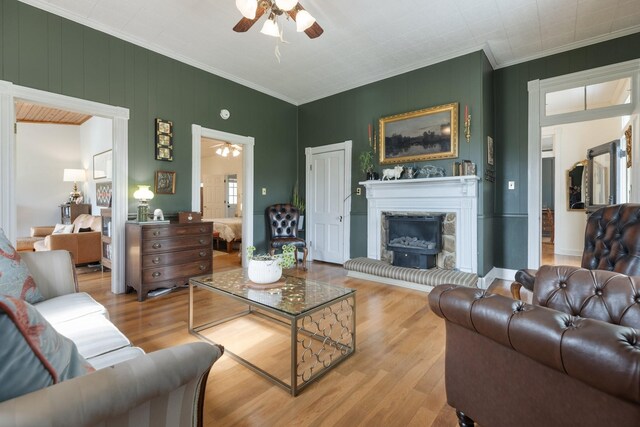 3310 Booker Ridge Rd, Mount Pleasant, TN 38474 - living area with a ceiling fan, ornamental molding, wood finished floors, and a fireplace with raised hearth